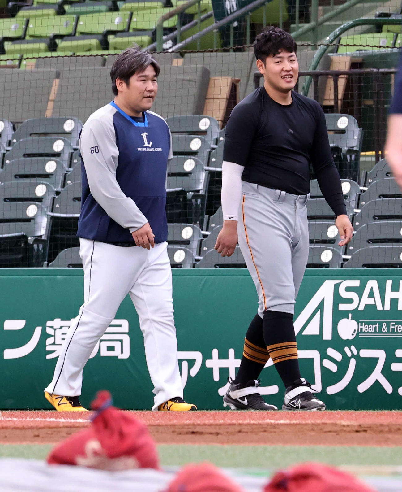 1軍の練習のみ合流した西武中村剛也（左）は巨人岡本和真と談笑しながら歩く（2022年6月撮影）