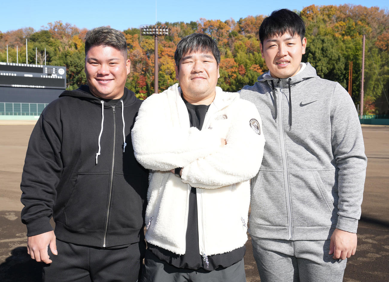 合同自主トレを終え笑顔で写真に納まる、左から西武渡部、中村、巨人岡本和