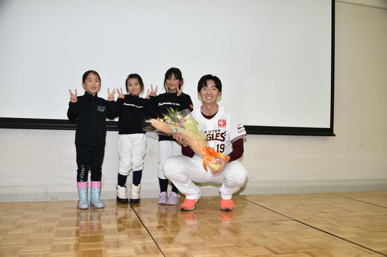 子どもたちから花束を贈呈され、笑顔の楽天荘司
