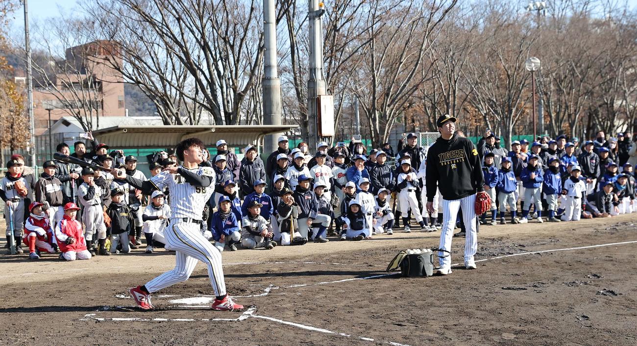 球児を背に豪快な打撃を披露する前川。トス役は才木（撮影・上田博志）