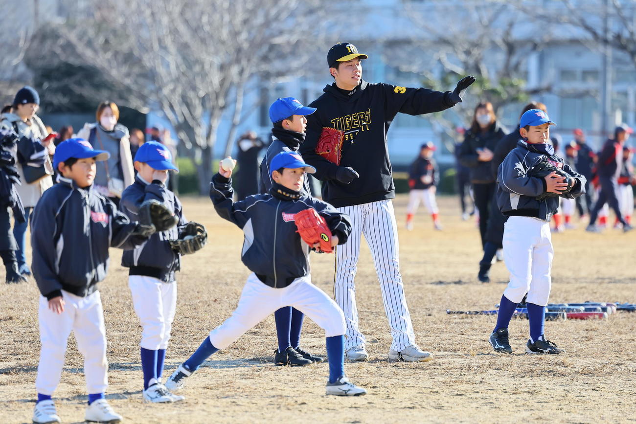 球児にキャッチボールの指導をする才木（撮影・上田博志）＝2023年12月23日、中川原グラウンド
