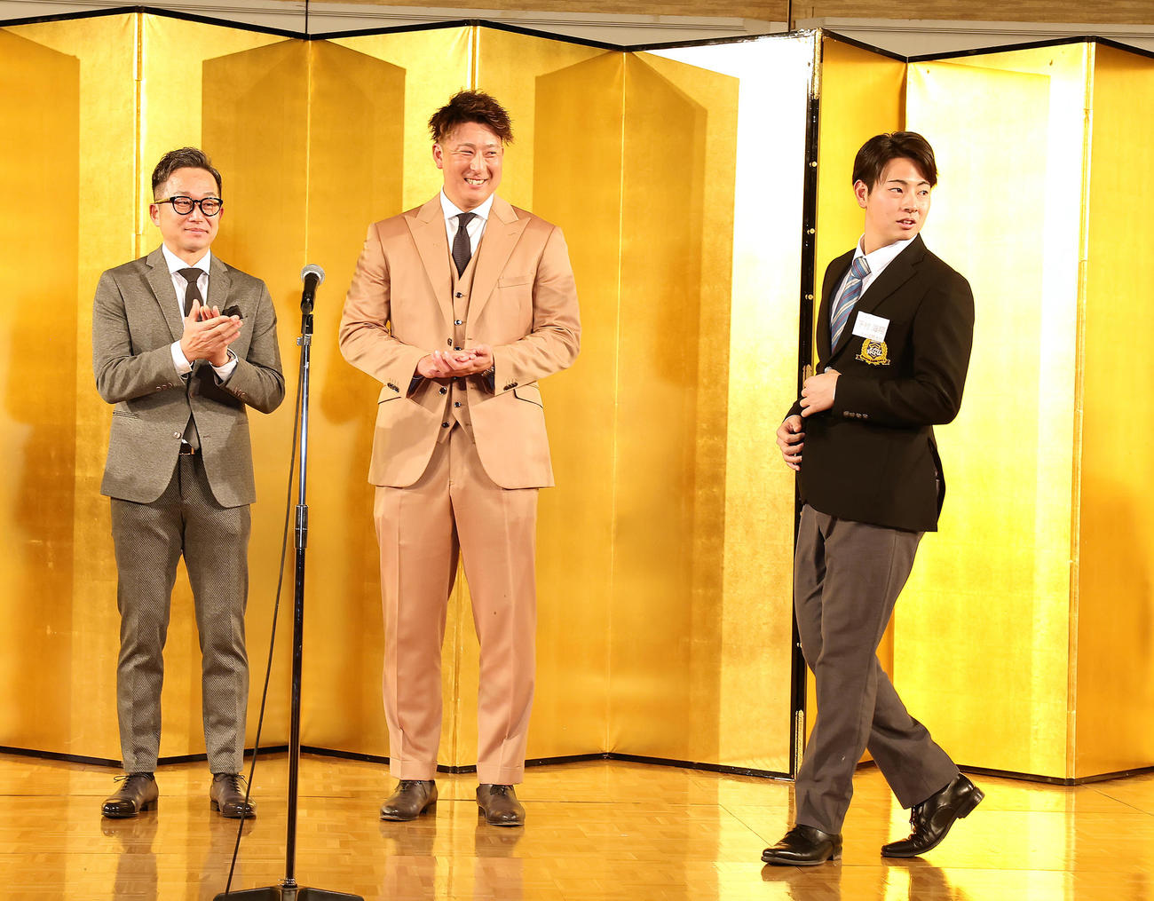 祝賀会で壇上に上がる阪神ドラフト1位下村（右）に拍手を送るヤクルト石川（左）とオリックス杉本（撮影・足立雅史）