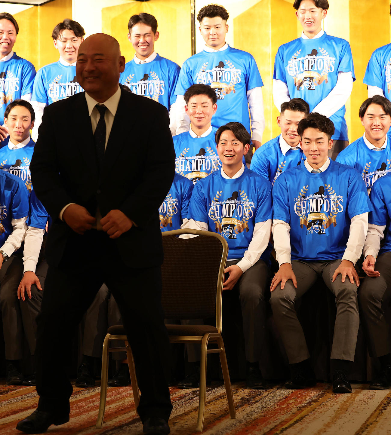 青学大祝賀会で一人ステージの前のイスに座り記念撮影に臨む安藤監督（手前左）に笑顔を見せる阪神ドラフト1位下村（同中央）、広島ドラフト1位常広（同右）ら（撮影・足立雅史）