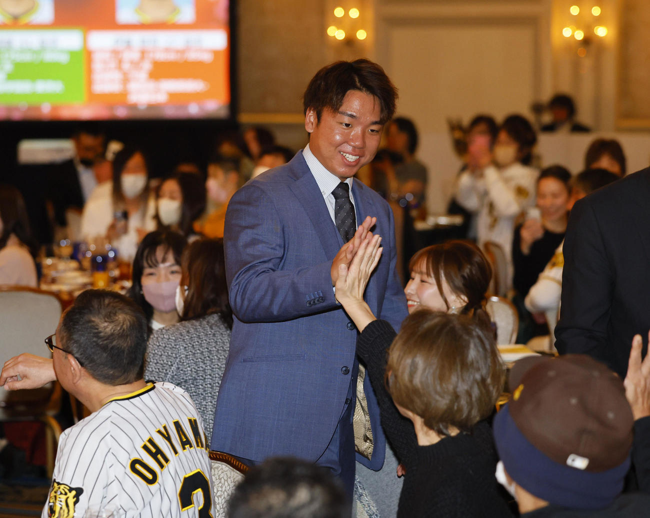 ファンクラブイベントの「クリスマスパーティー」で、ファンとハイタッチをする阪神村上（撮影・藤尾明華）