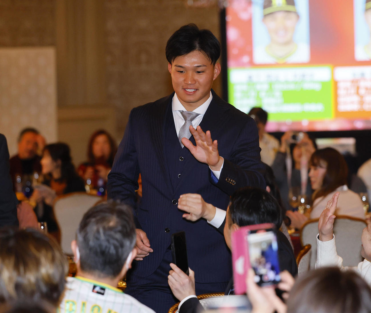 ファンクラブイベントの「クリスマスパーティー」でファンとタッチを交わす阪神森下（撮影・藤尾明華）