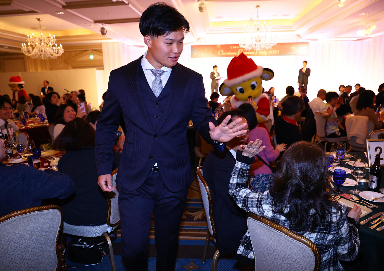 ファンクラブイベントの「クリスマスパーティー」でファンとタッチを交わす阪神森下（撮影・藤尾明華）