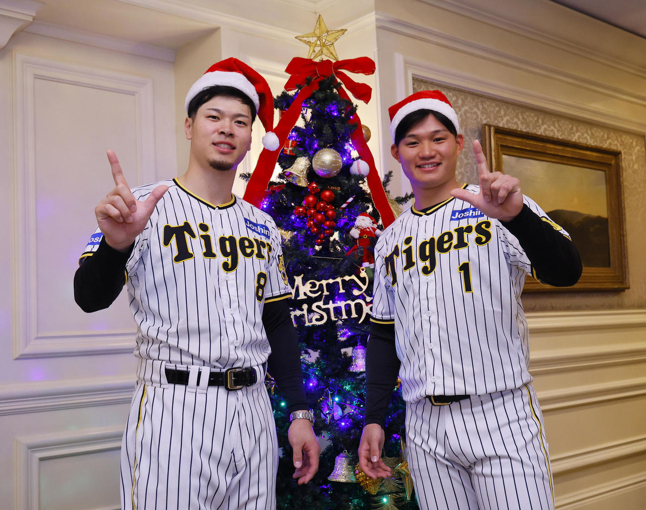 ファンクラブイベントの「クリスマスパーティー」でツリーの前で写真に納まる阪神佐藤輝（左）と森下（撮影・藤尾明華）