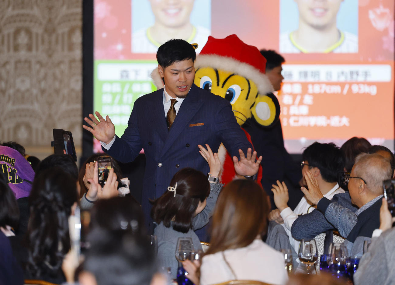 ファンクラブイベントの「クリスマスパーティー」でファンとタッチを交わす阪神佐藤輝（撮影・藤尾明華）