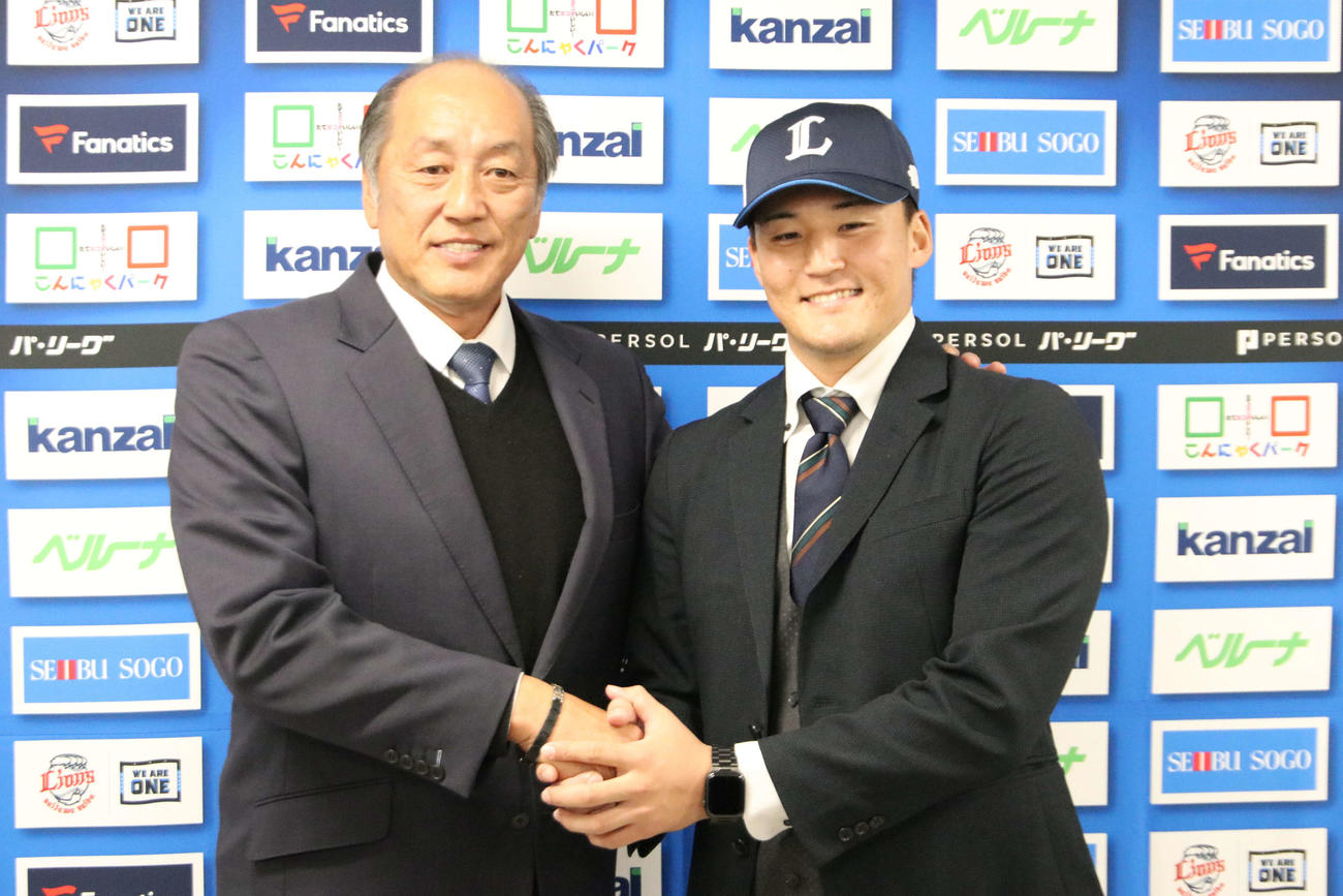 渡辺GM（左）と握手を交わす西武元山（撮影・山崎純一）