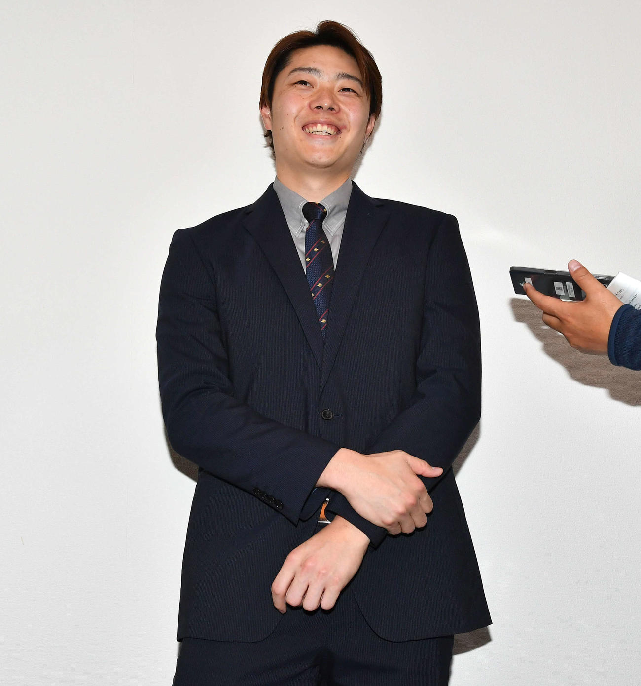 増額で契約更改し、囲み取材で笑顔を見せる松本裕（撮影・岩下翔太）