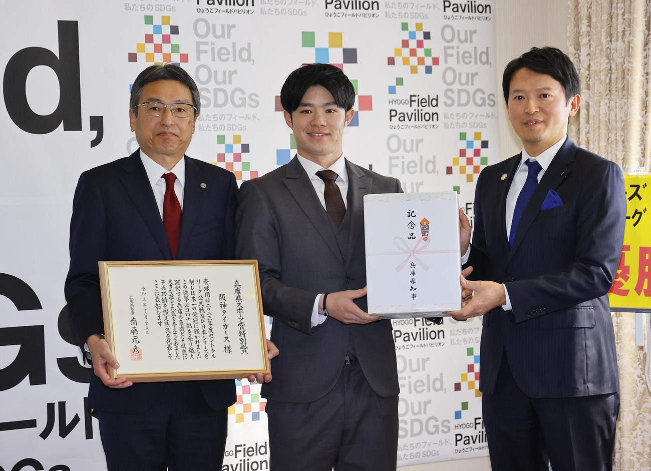 兵庫県スポーツ賞特別賞贈呈式で、斎藤元彦兵庫県知事（右）から賞状と記念品を贈られた阪神中野（中央）と百北球団社長（撮影・藤尾明華）
