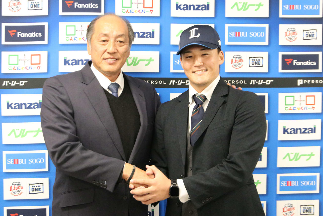 渡辺GM（左）と握手を交わす西武元山（撮影・山崎純一）