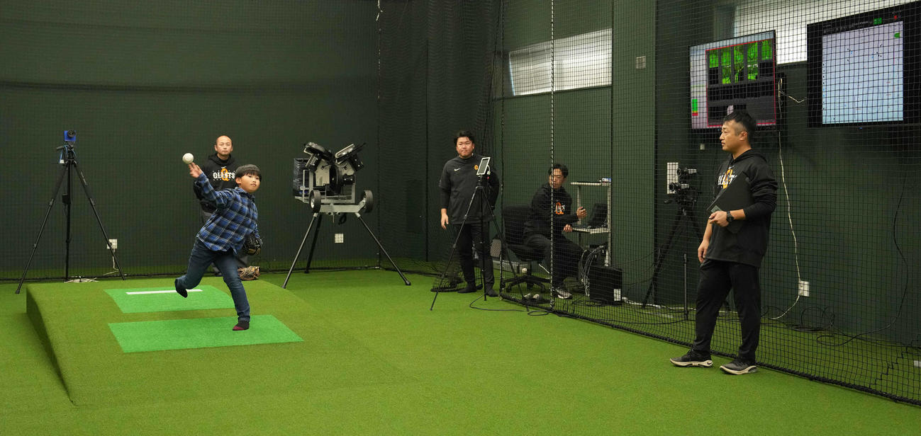 トレーニング棟の動作解析室で投球する、内覧会に参加した子供（撮影・鈴木みどり）