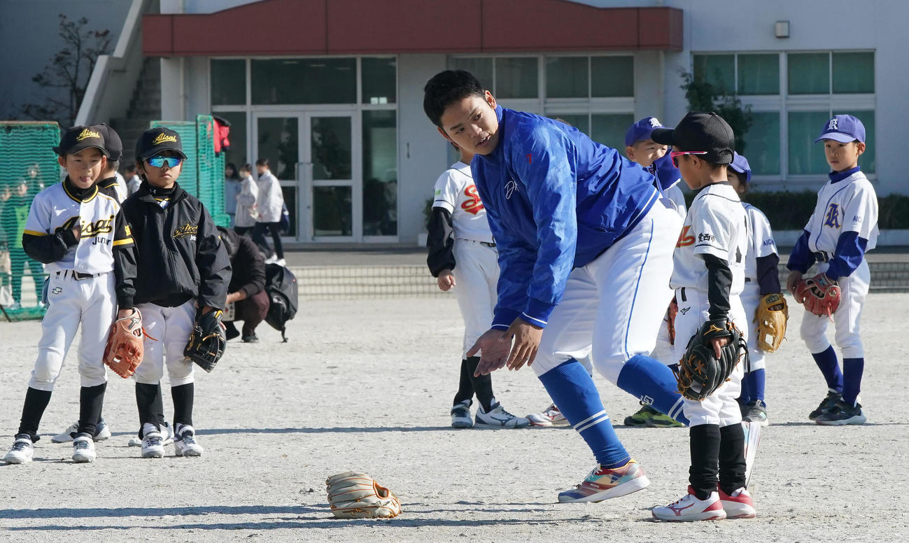 野球教室に参加し子どもたちにゴロ捕球のアドバイスをする根尾（中央）（撮影・森本幸一）