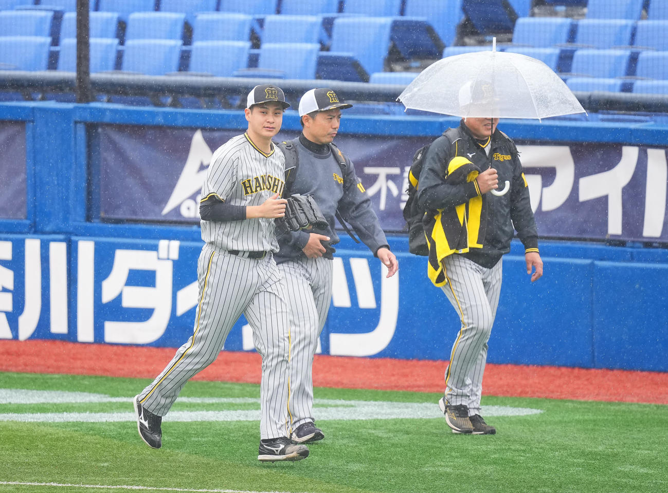 4月15日、DeNA戦が雨天中止となり、雨の中を走ってブルペンへ向かう阪神大竹（左）（撮影・垰建太）