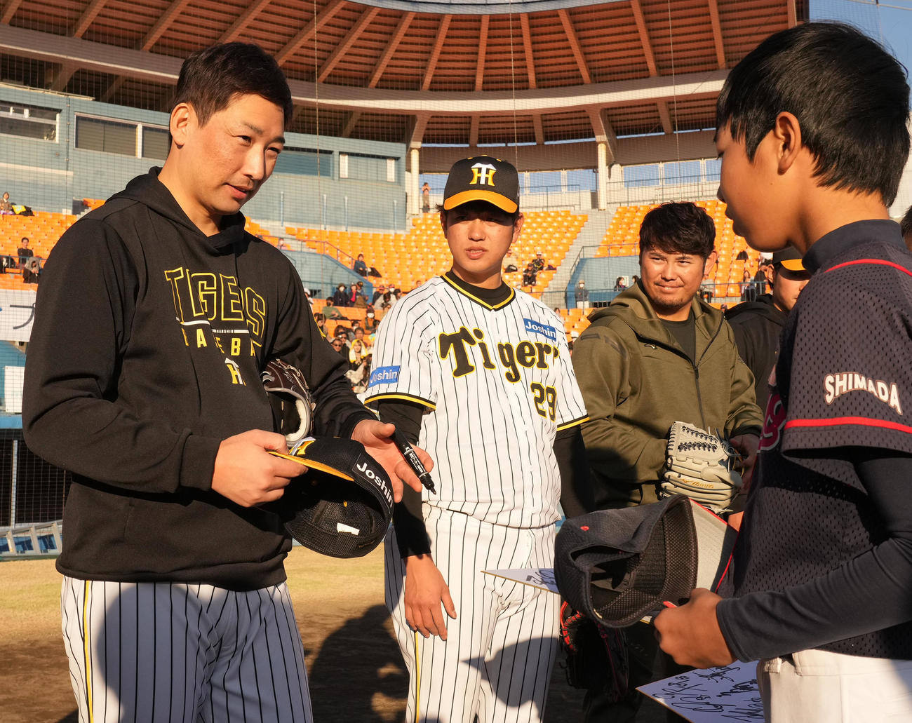 野球教室に参加しサイン入り帽子のプレゼントを渡す岩崎（左）（撮影・森本幸一）