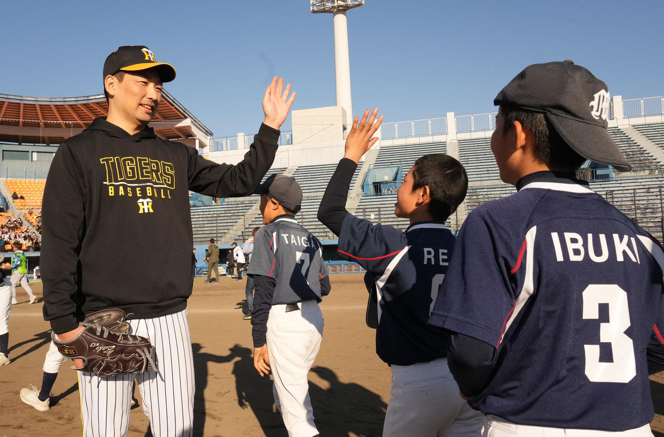野球教室に参加し子どもたちとタッチを交わす岩崎（左）（撮影・森本幸一）