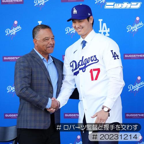 12月14日、入団会見でドジャースのユニホームに袖を通しロバーツ監督と握手を交わす大谷（撮影・菅敏）