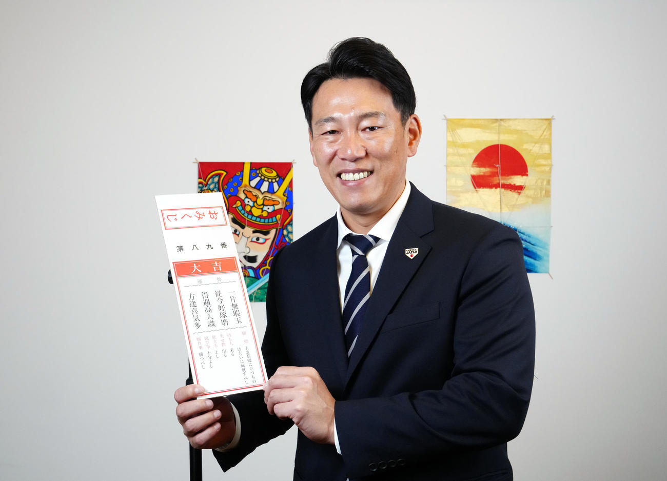 大吉のおみくじに手を添え、笑顔を見せる侍ジャパン井端監督（撮影・江口和貴）