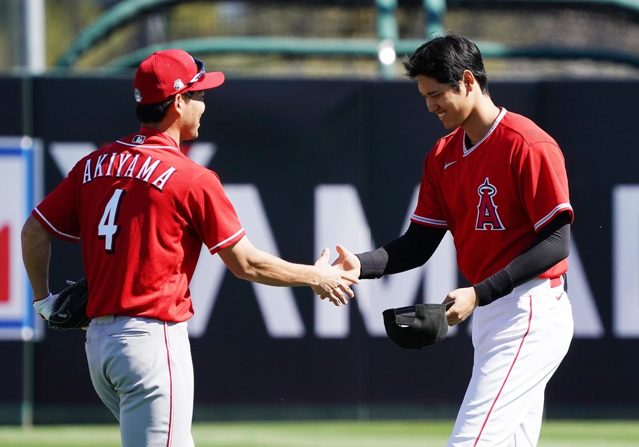 試合前にレッズ秋山（左）に握手であいさつするエンゼルス大谷（2020年2月25日撮影）