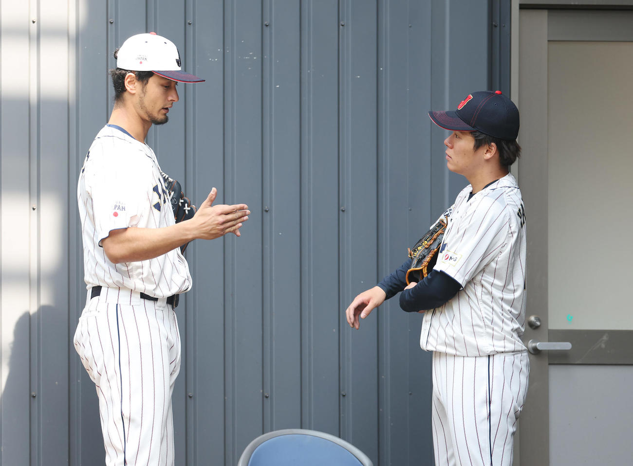 2月、ブルペンで投球練習を終えた山本（右）と言葉を交わすダルビッシュ