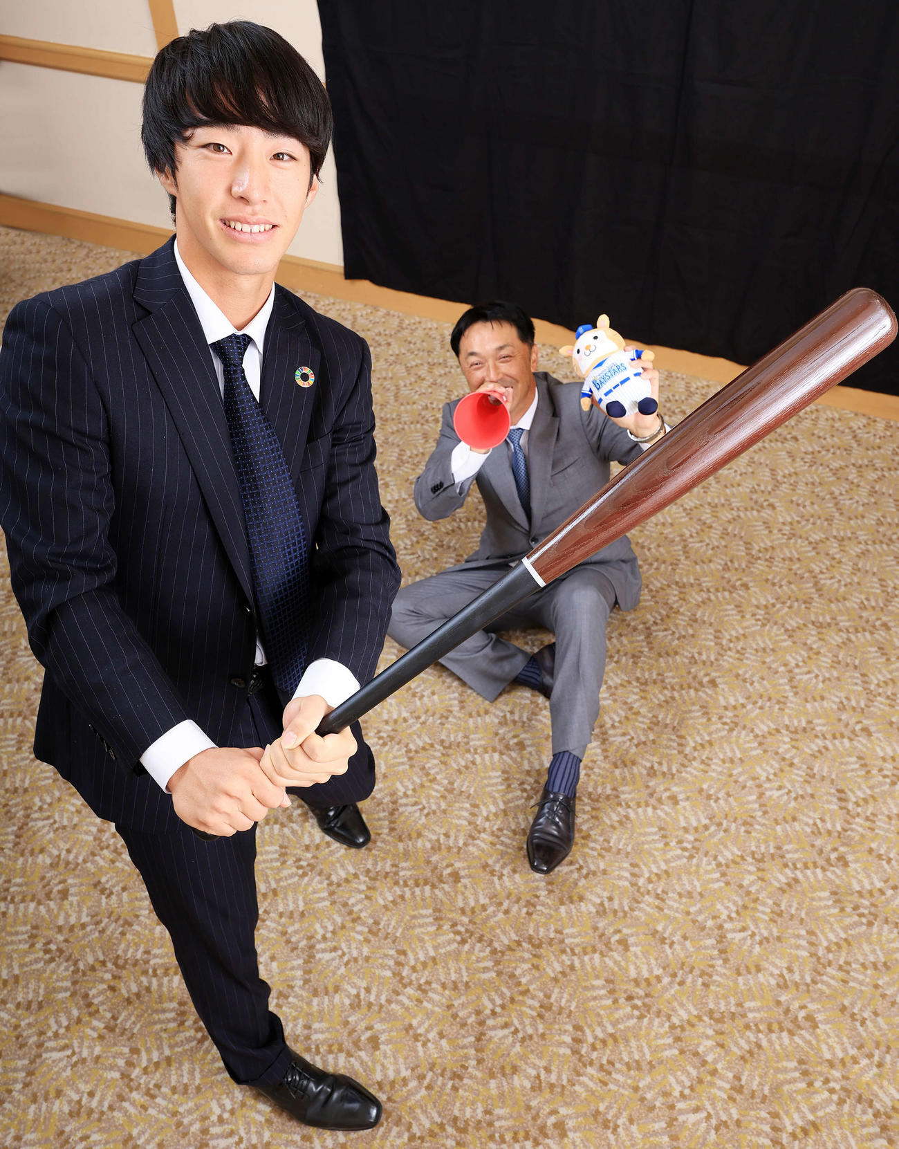 DeNAドラフト1位の度会（手前）は、宮本慎也氏からメガホンで激励され笑顔でバットを振る（撮影・浅見桂子）