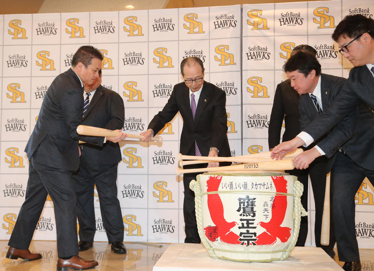 鏡開きの前に、樽を割るバットを配る王球団会長（撮影・梅根麻紀）