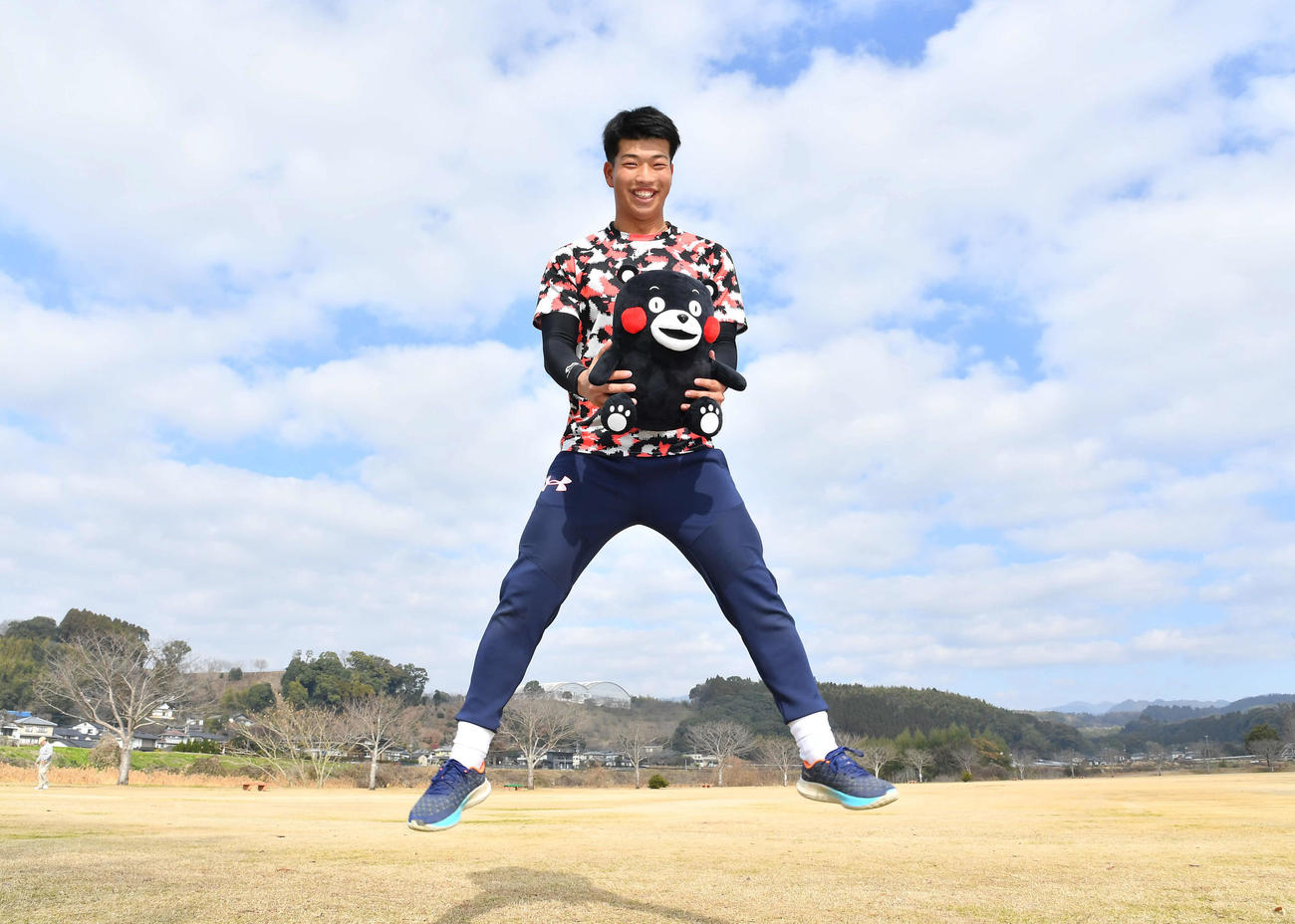 自主トレを公開した阪神百崎は、くまモンのぬいぐるみを手に笑顔でジャンプ（撮影・岩下翔太）