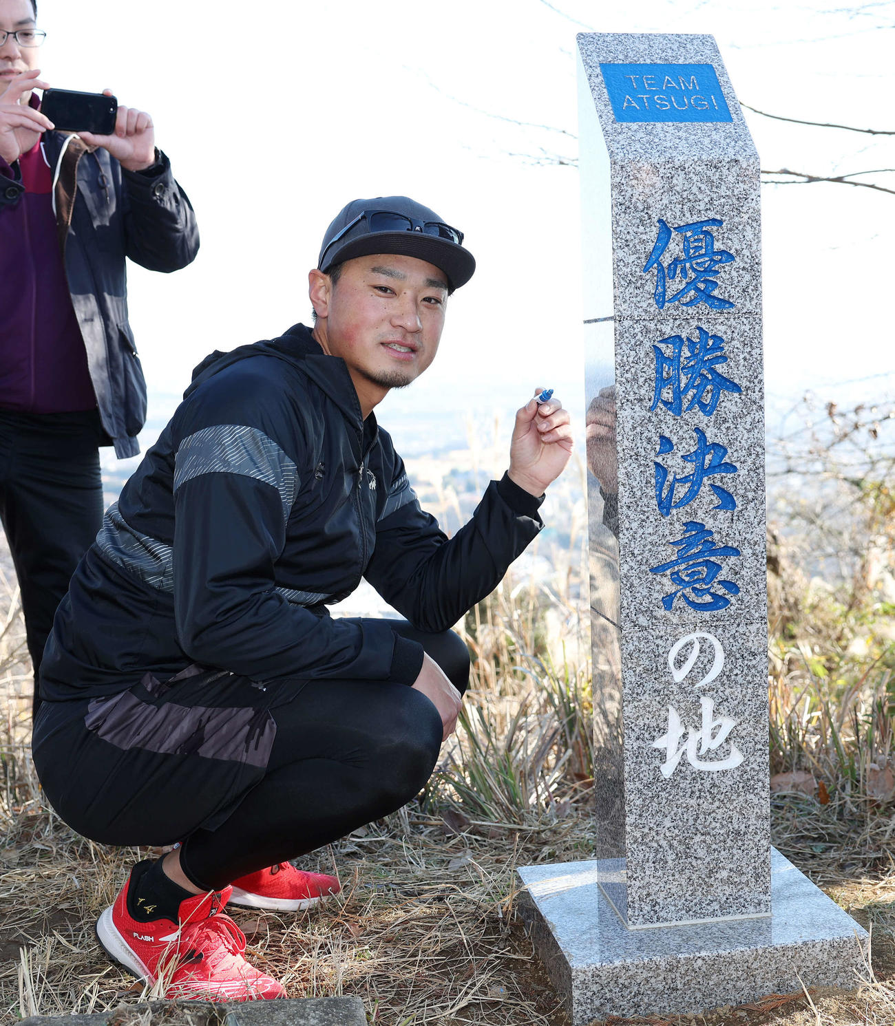山頂の「優勝決意の地」にサインをするDeNA石田（撮影・宮地輝）