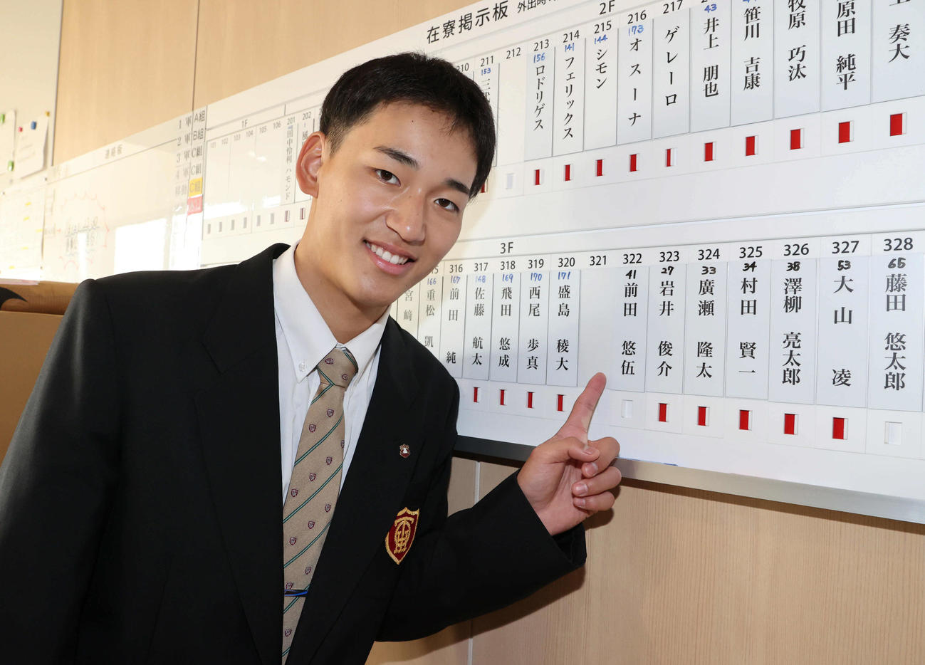 若鷹寮に到着し、名札を指さす前田