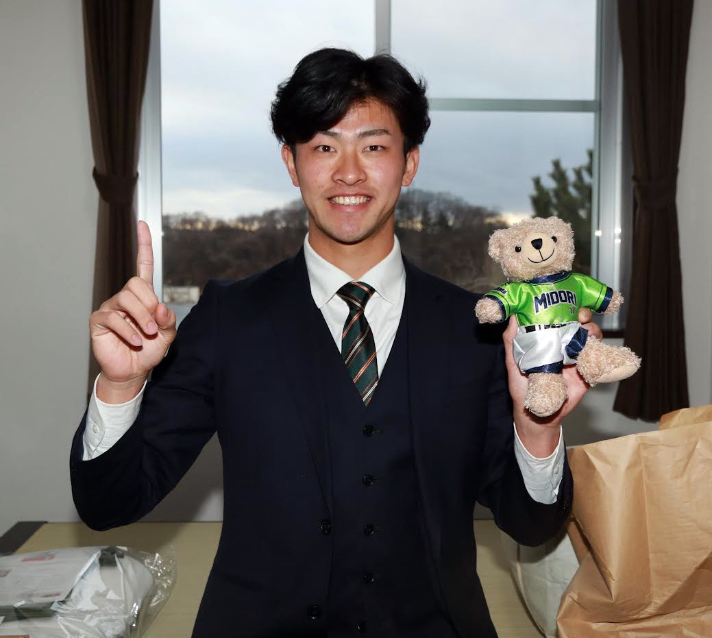 背番号「17」を背負ったくまのぬいぐるみを持ち笑顔の楽天ドラフト1位古謝