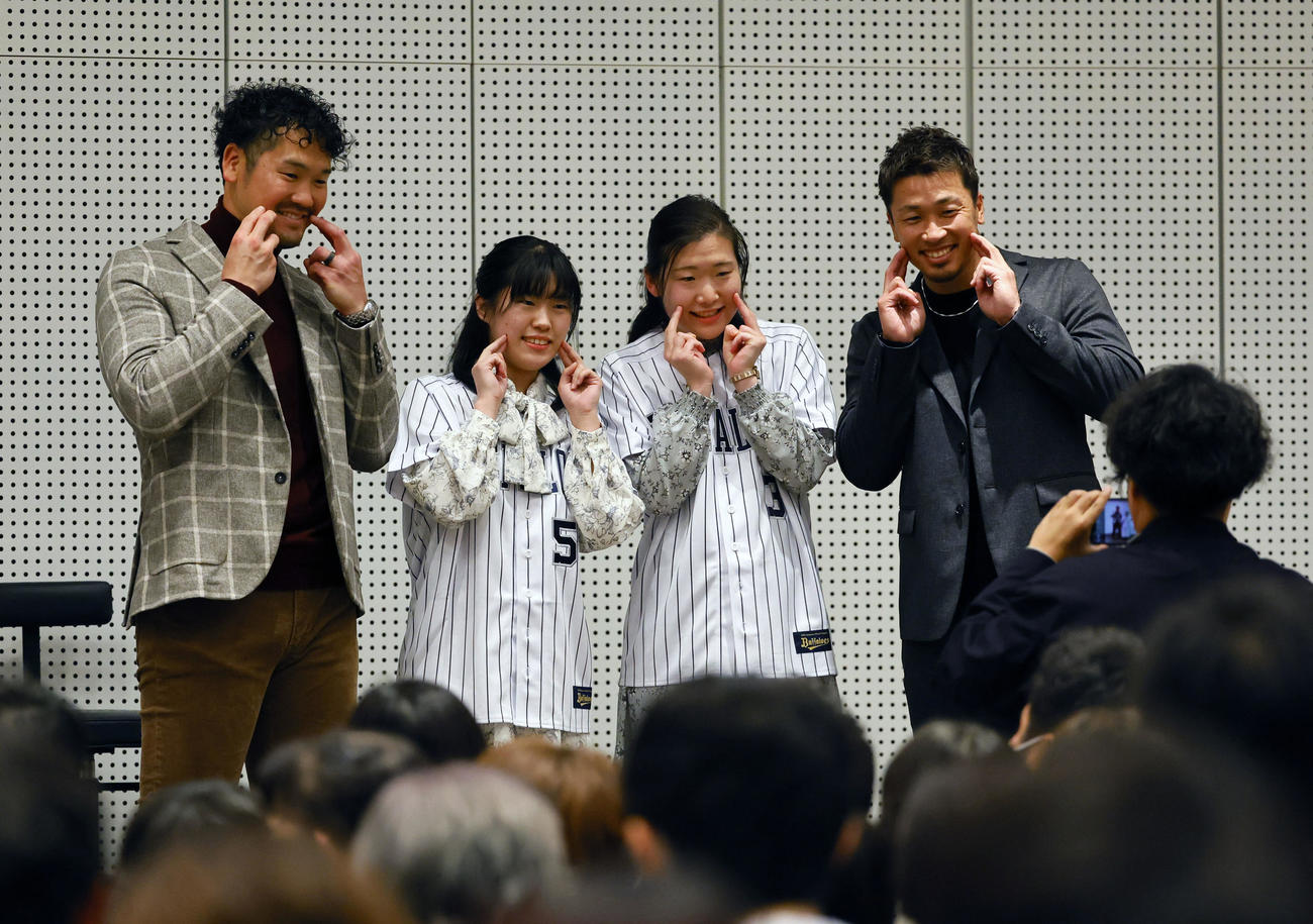 ファンミーティングで写真撮影するT－岡田（左）と安達（撮影・藤尾明華）