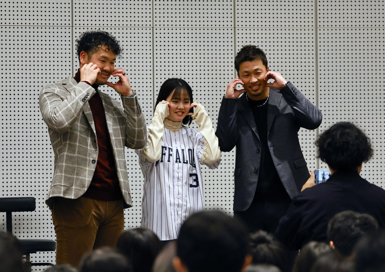 ファンミーティングでファンと写真撮影するT－岡田（左端）と安達（右端）（撮影・藤尾明華）