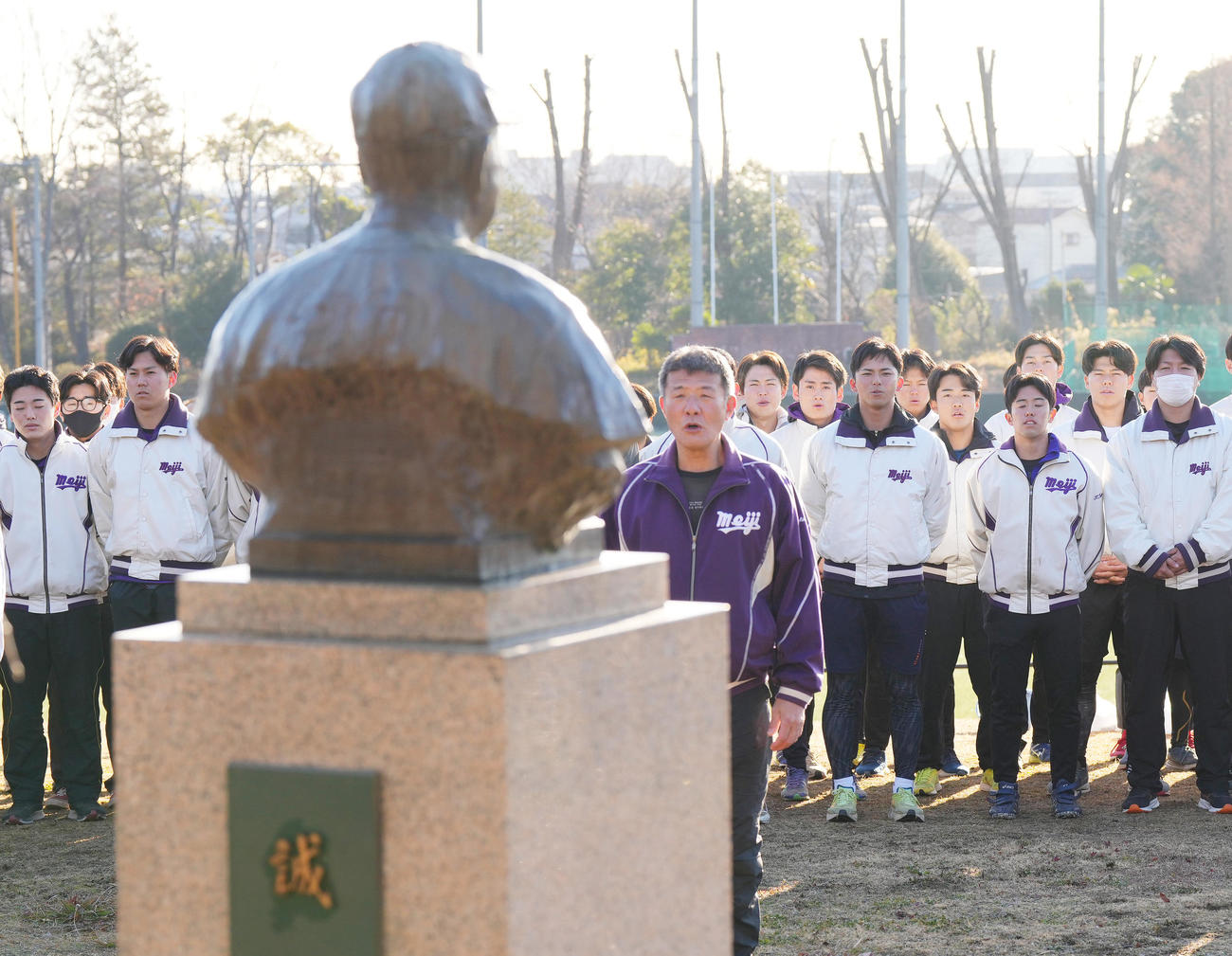 練習初めを前に島岡吉郎氏の銅像に向かって校歌を歌う明大・宗山（右から7人目）（撮影・菅敏）