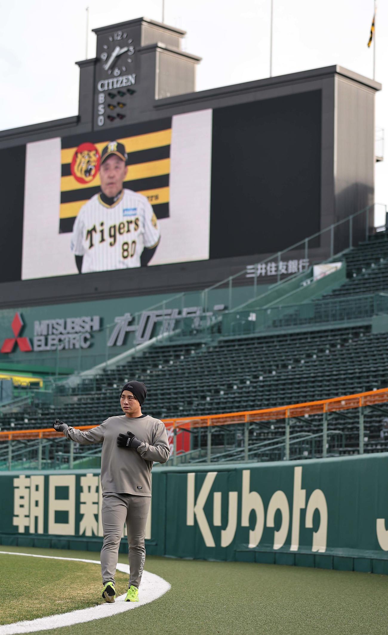 岡田監督の新年あいさつが流れるバックスクリーンを背にウオーミングアップをする木浪（撮影・上田博志）