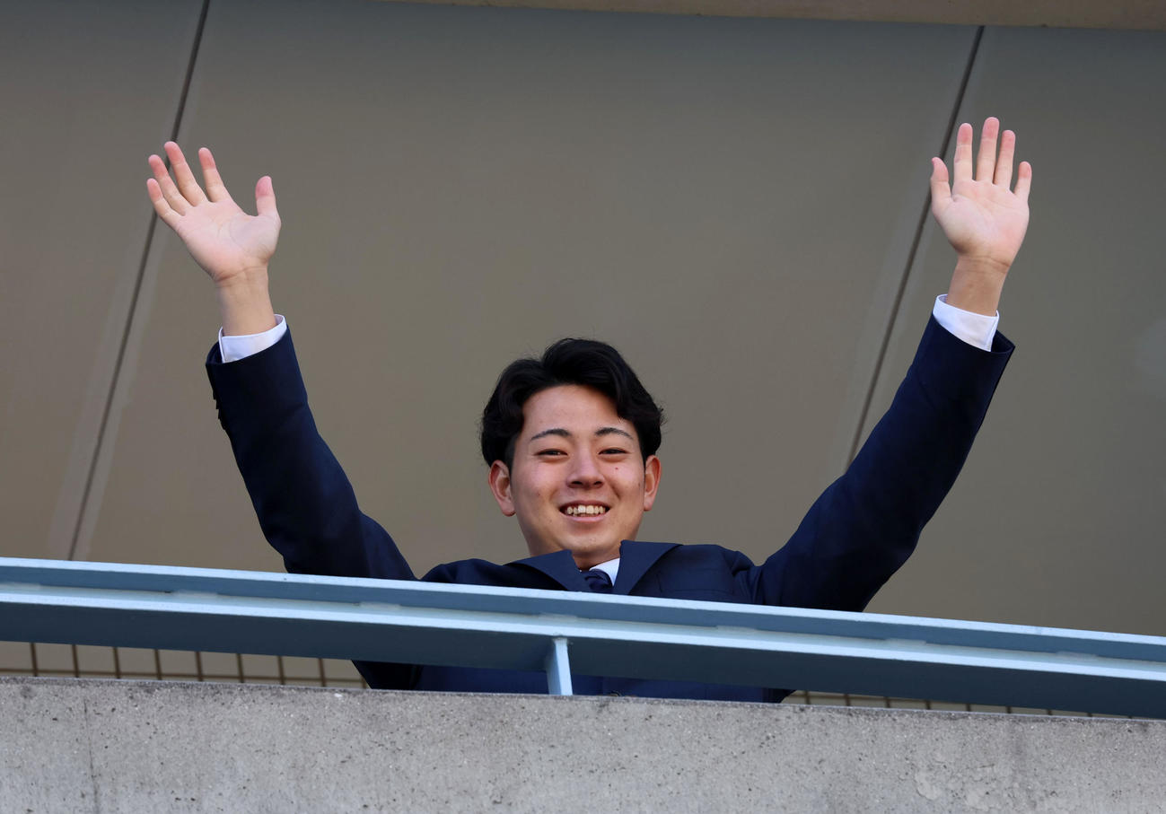 虎風荘へ入寮し部屋のベランダから手を振る下村（撮影・加藤哉）