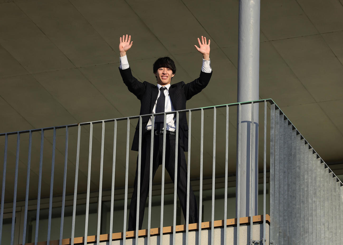 青星寮に入寮し、ベランダから手を振るDeNAドラフト1位度会（撮影・足立雅史）