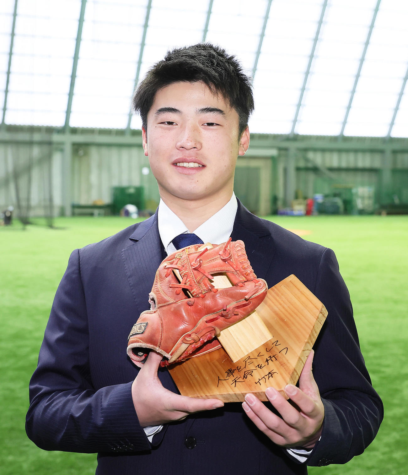DeNA育成5位近藤は青星寮に入寮し、初めて買ってもらったグラブと恩師のメッセージが入った自作の台を手に笑顔（撮影・足立雅史）