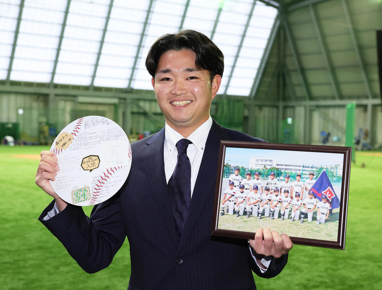 DeNAドラフト5位石田裕は青星寮に入寮し、寄せ書きと写真を手に笑顔（撮影・足立雅史）