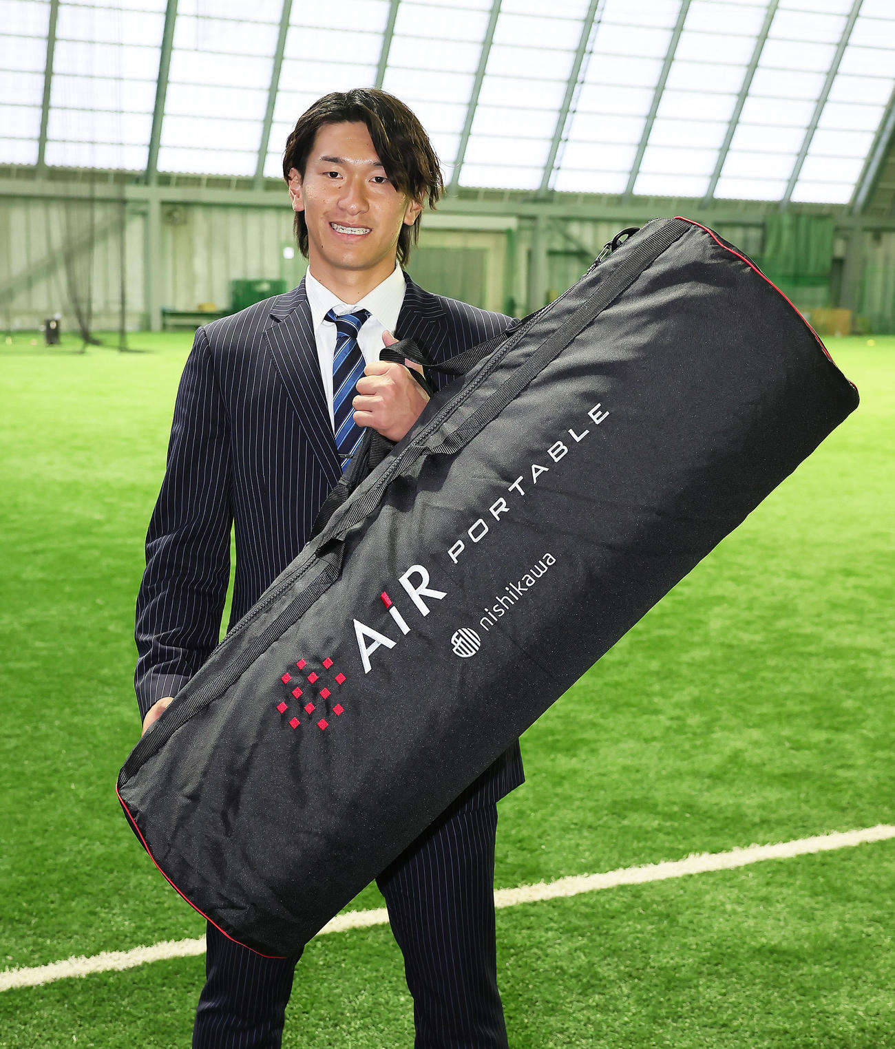 ドラフト6位井上は青星寮に入寮し、愛用のマットレスを手に笑顔を見せる（撮影・足立雅史）