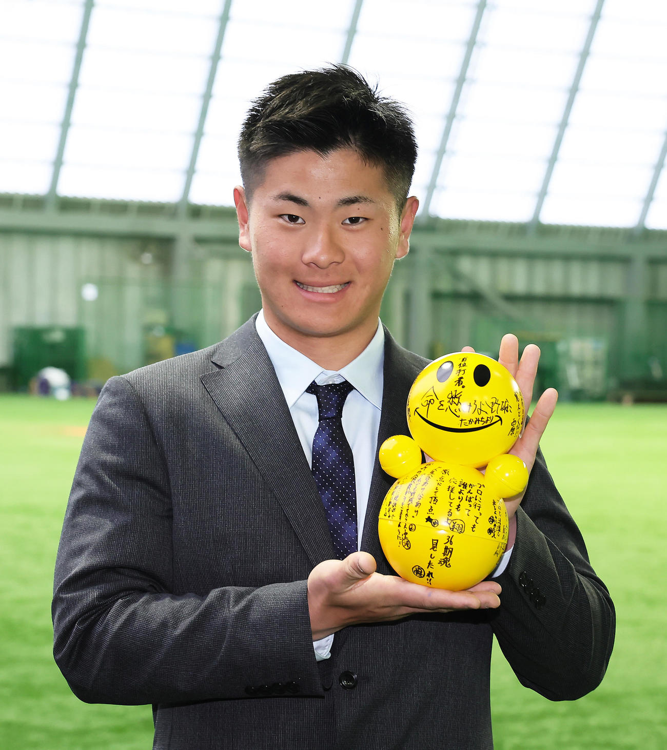 DeNA育成1位の高見沢は青星寮に入寮し、起き上がりこぼしを手に笑顔（撮影・足立雅史）