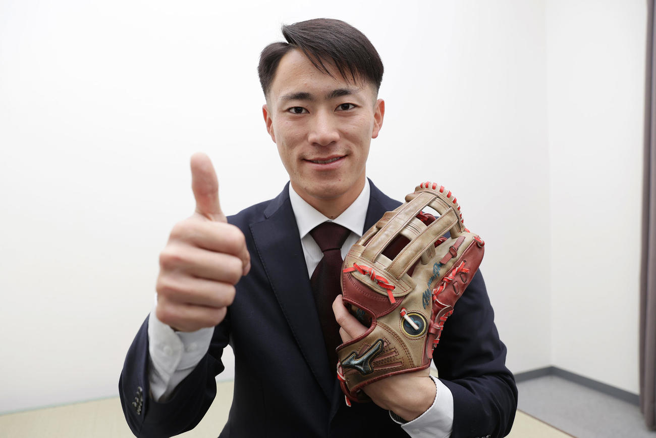 入寮し持ち込んだグラブを手にサムズアップポーズを見せる阪神育成2位の福島（撮影・前田充）