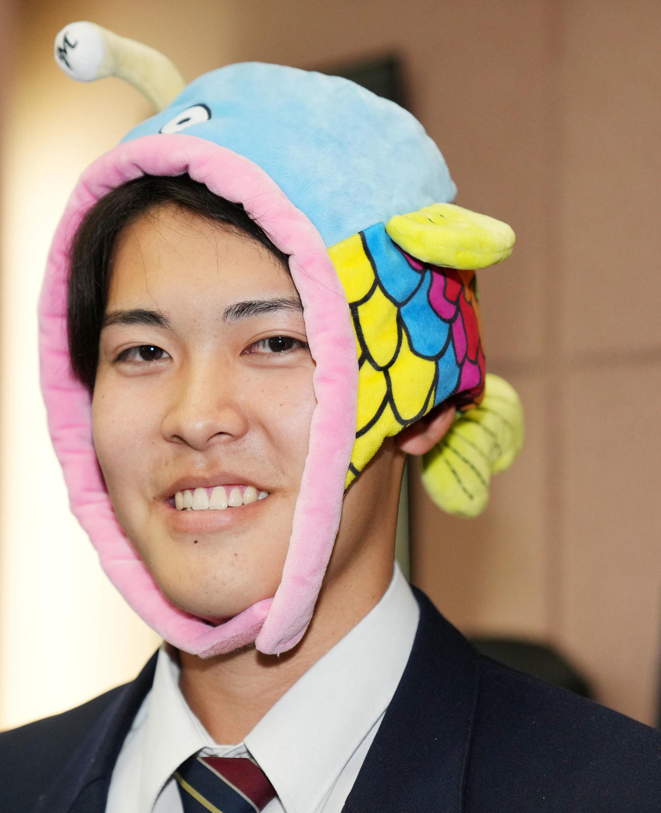 入寮の際に持参した謎の魚をかぶり笑顔をみせるロッテドラフト4位の幕張総合・早坂（撮影・横山健太）