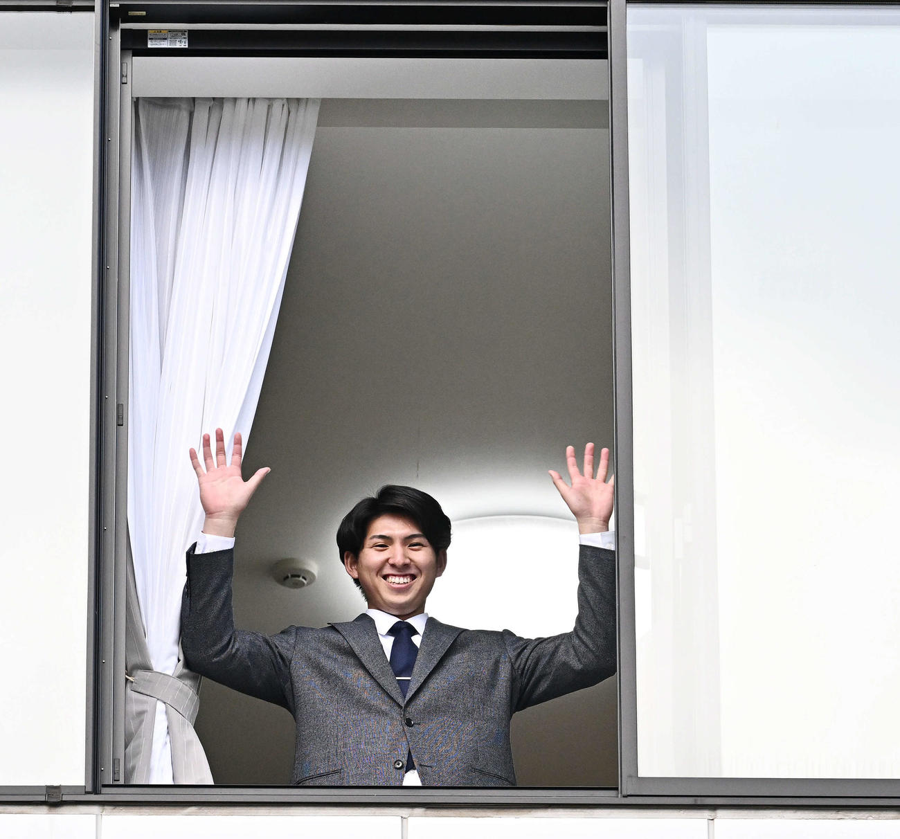 入寮し部屋から手を振る西武ドラフト1位の国学院大・武内（撮影・滝沢徹郎）