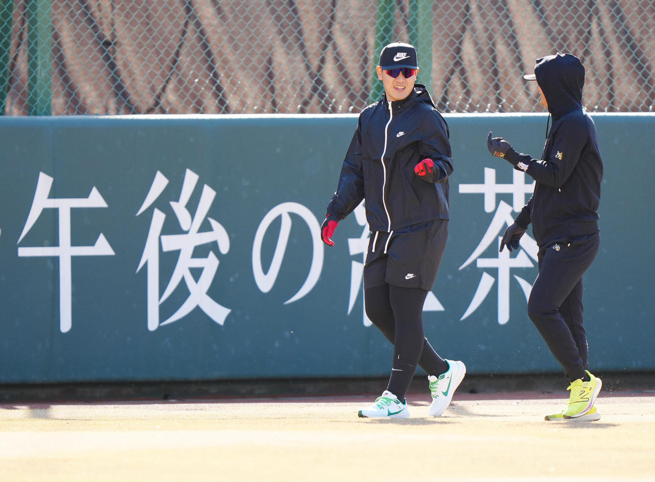 自主トレ中、巨人吉川（右）と言葉を交わす岡本和（撮影・江口和貴）
