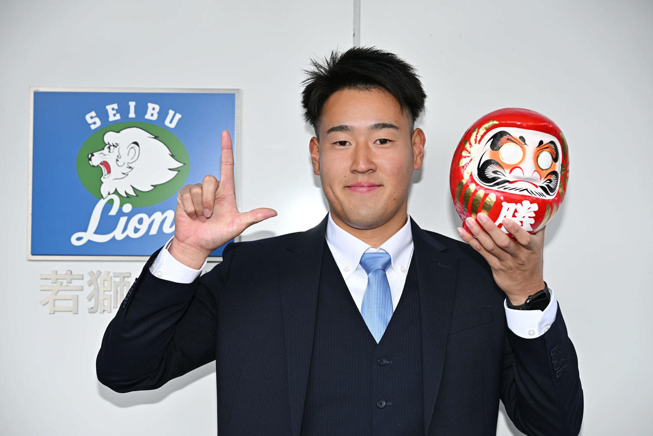 入寮する西武ドラフト2位の大商大・上田は持ち込んだだるまを手に記念撮影する（撮影・滝沢徹郎）