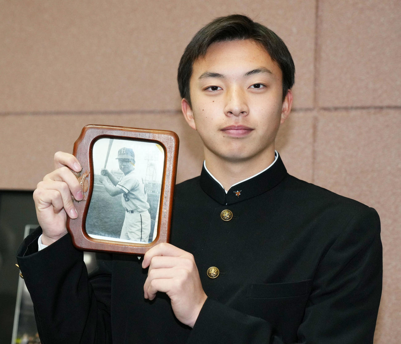 入寮に持参した祖父の写真を手に笑顔をみせるロッテドラフト育成1位の星稜・武内（撮影・横山健太）