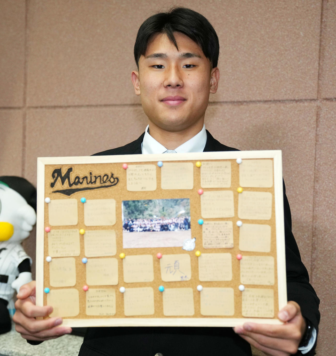 入寮の際に持ってきた寄せ書きを手に笑顔をみせるロッテドラフト育成4位の延岡学園・藤田（撮影・横山健太）