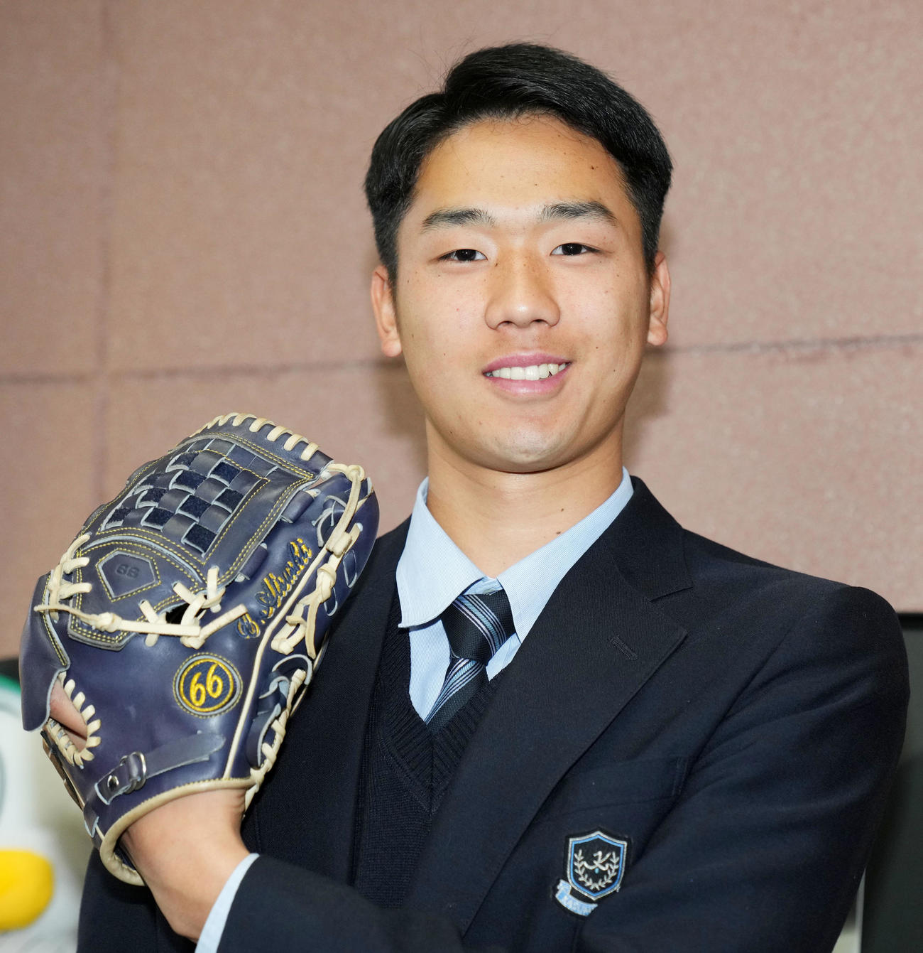 入寮で持参したグラブを手に笑顔をみせるロッテドラフト3位の霞ケ浦・木村（撮影・横山健太）