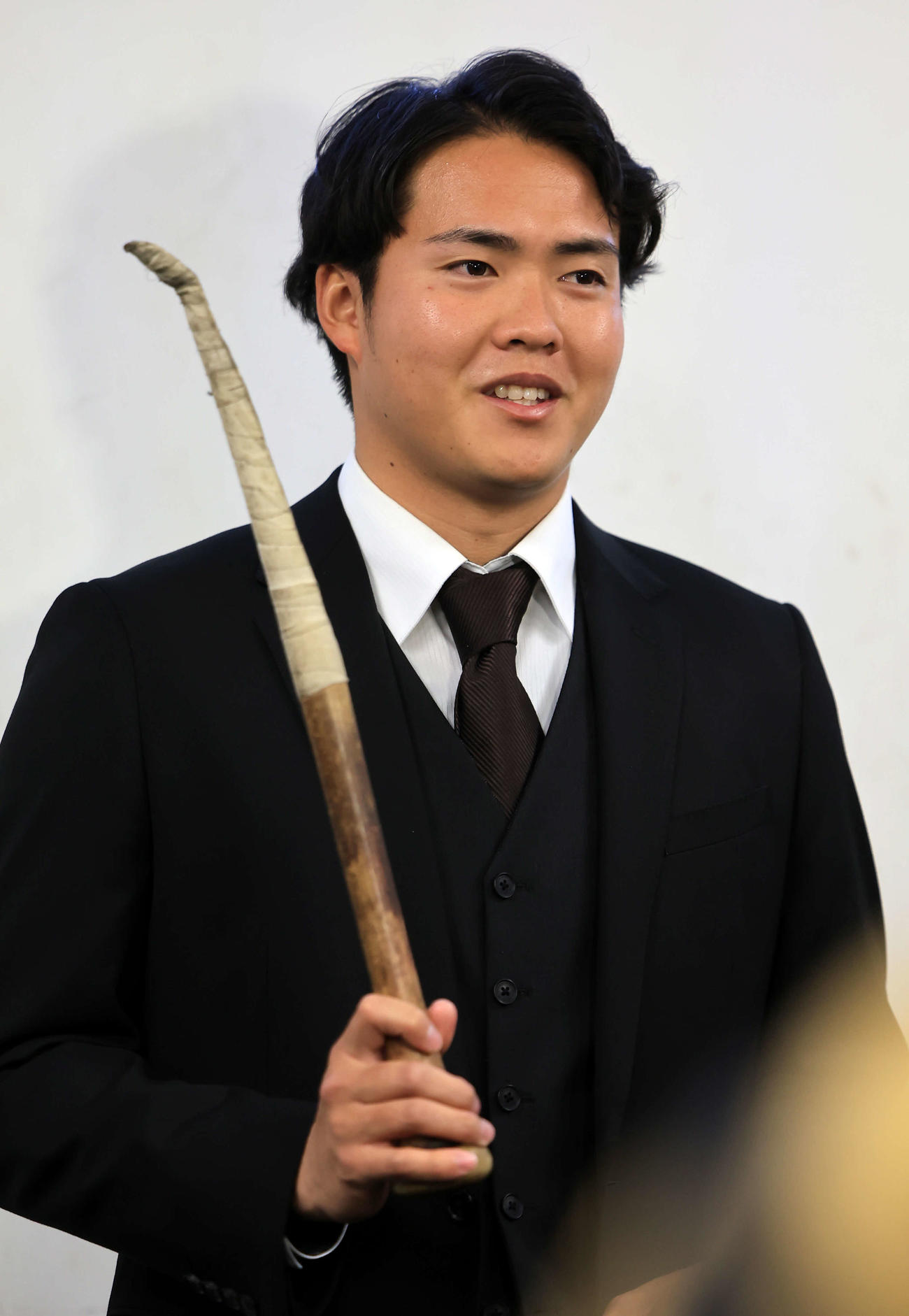 ヤクルト選手寮に入寮したドラフト2位の松本健は、シャドーピッチング用に持参した折れたバットを手に報道陣の質問に答える（撮影・浅見桂子）